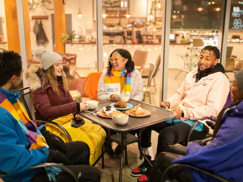 Friends enjoy coffee on a winter patio